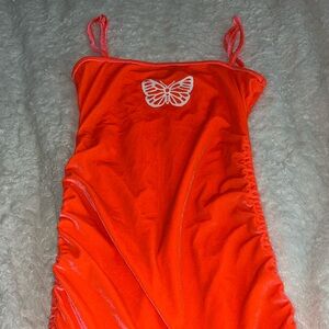 Neon orange velvet spaghetti strapped
dress with ruched detailing on the sides